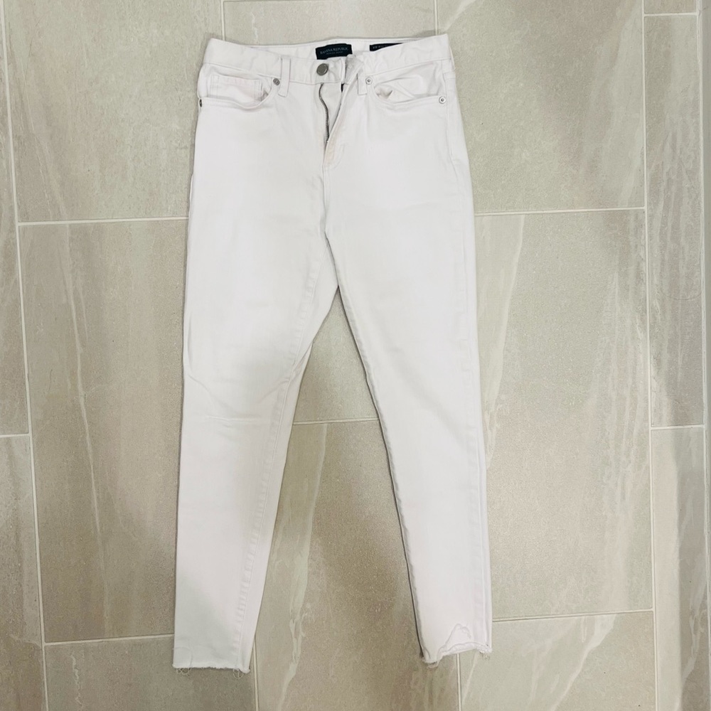 Banana Republic white mid-rise skinny jeans, lightly distressed hem. Size 27.